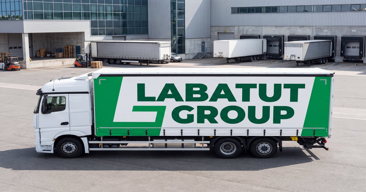 Camion Labatut LVI avec logo pleine bâche sur un site logistique, location de véhicule industriel avec chauffeur